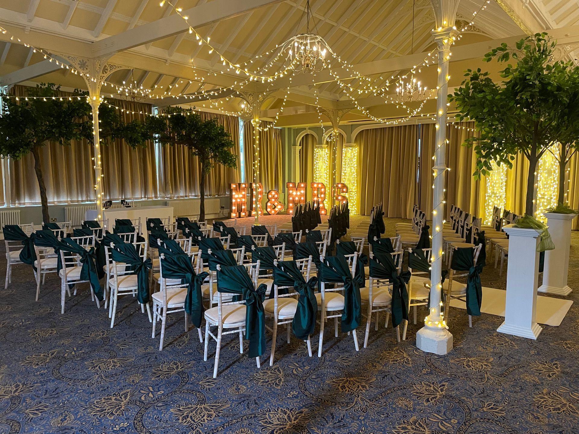 Warm white fairy canopy and fairy light pillars compliment racing green accents. Decor and Lights from Exclusive Entertainments, Harrogate, Yorkshire