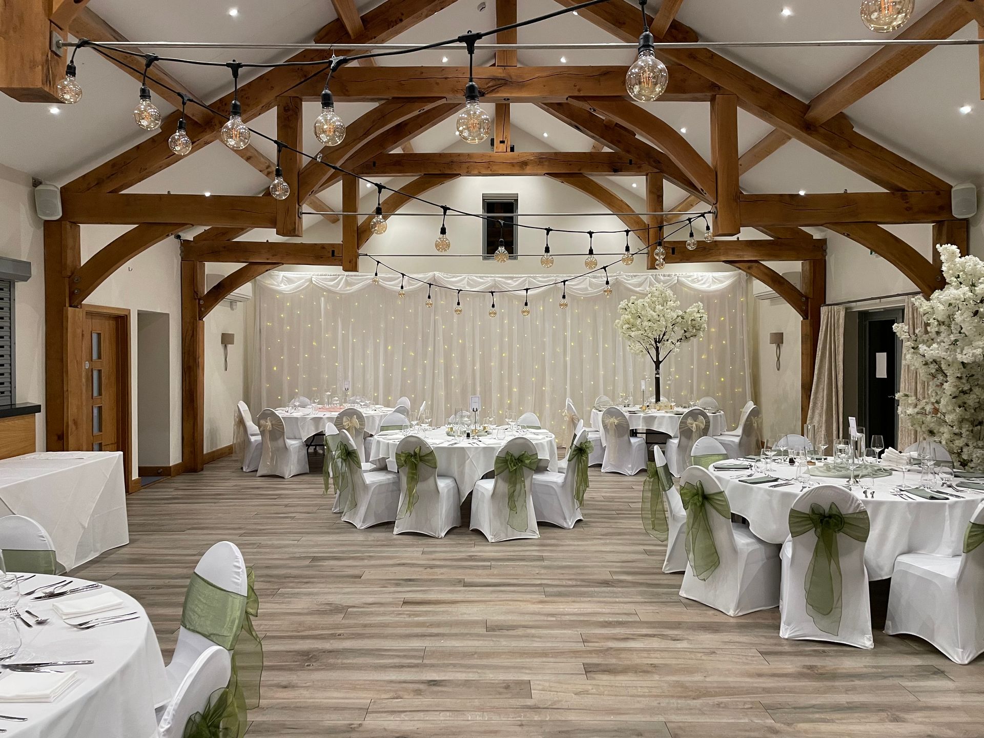 Large ceiling lights and white lighting showcases a fresh white and soft green colour theme at a wedding location. Decor and Lights from Exclusive Entertainments, Harrogate, Yorkshire
