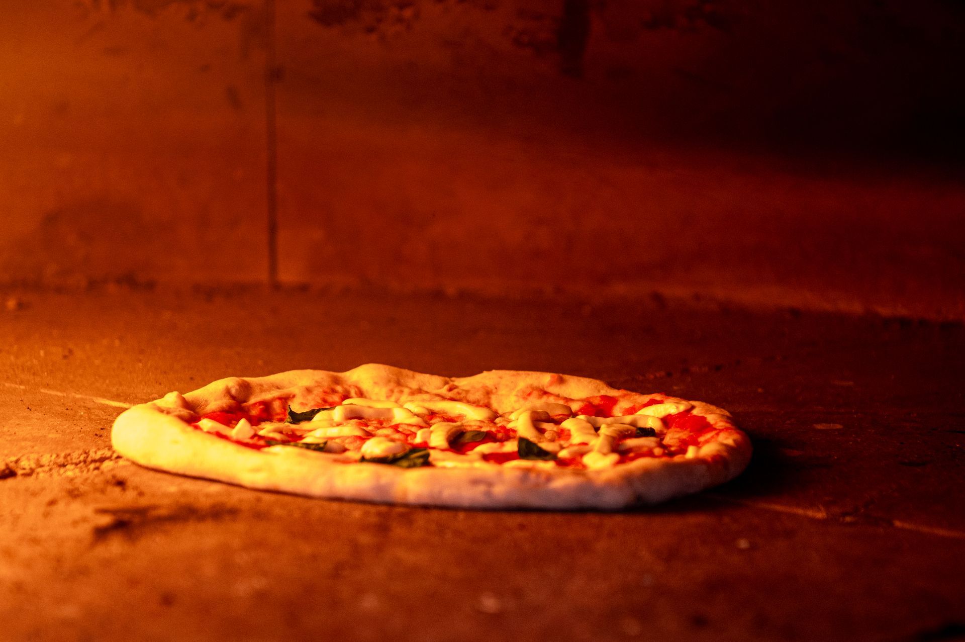 Una pizza è appoggiata su un bancone di marmo.