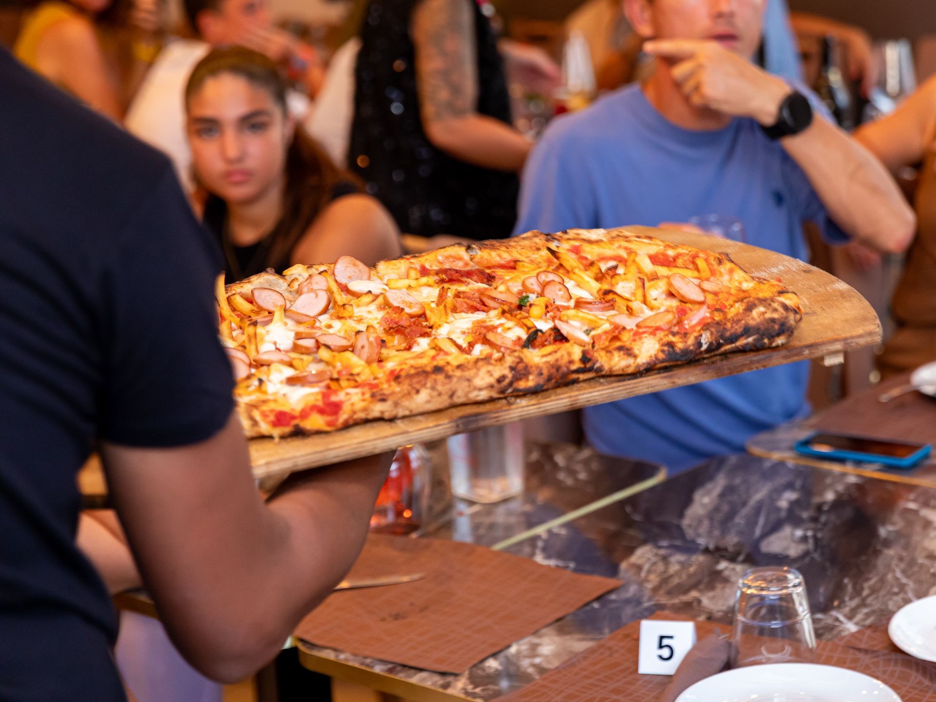 Un tavolo con quattro pizze e una bottiglia di champagne sopra