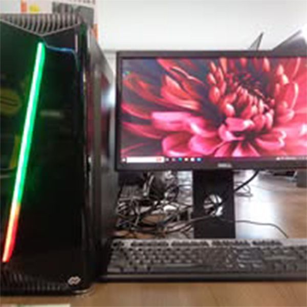 A computer is sitting on a desk next to a monitor and keyboard.