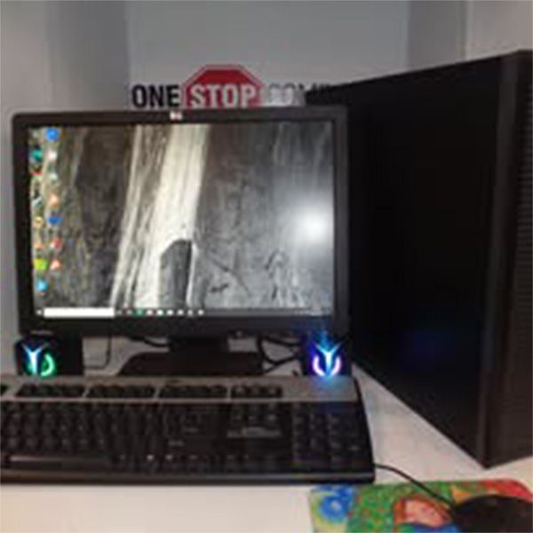A computer is sitting on a desk next to a sign that says one stop