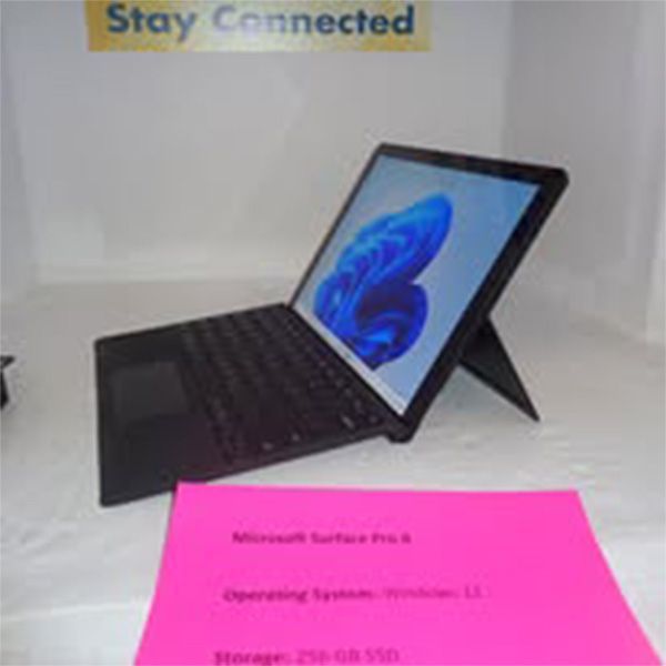 A laptop is sitting on a table next to a sign that says stay connected