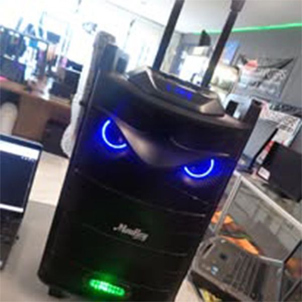 A speaker that looks like an owl with blue eyes is sitting on a table.