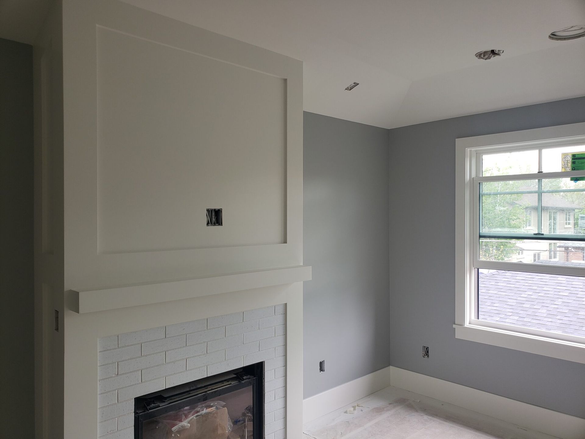 A living room with a fireplace and a window.