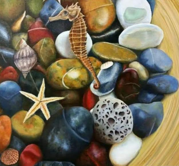 Close-up of a collection of colorful beach stones, shells, and a seahorse.