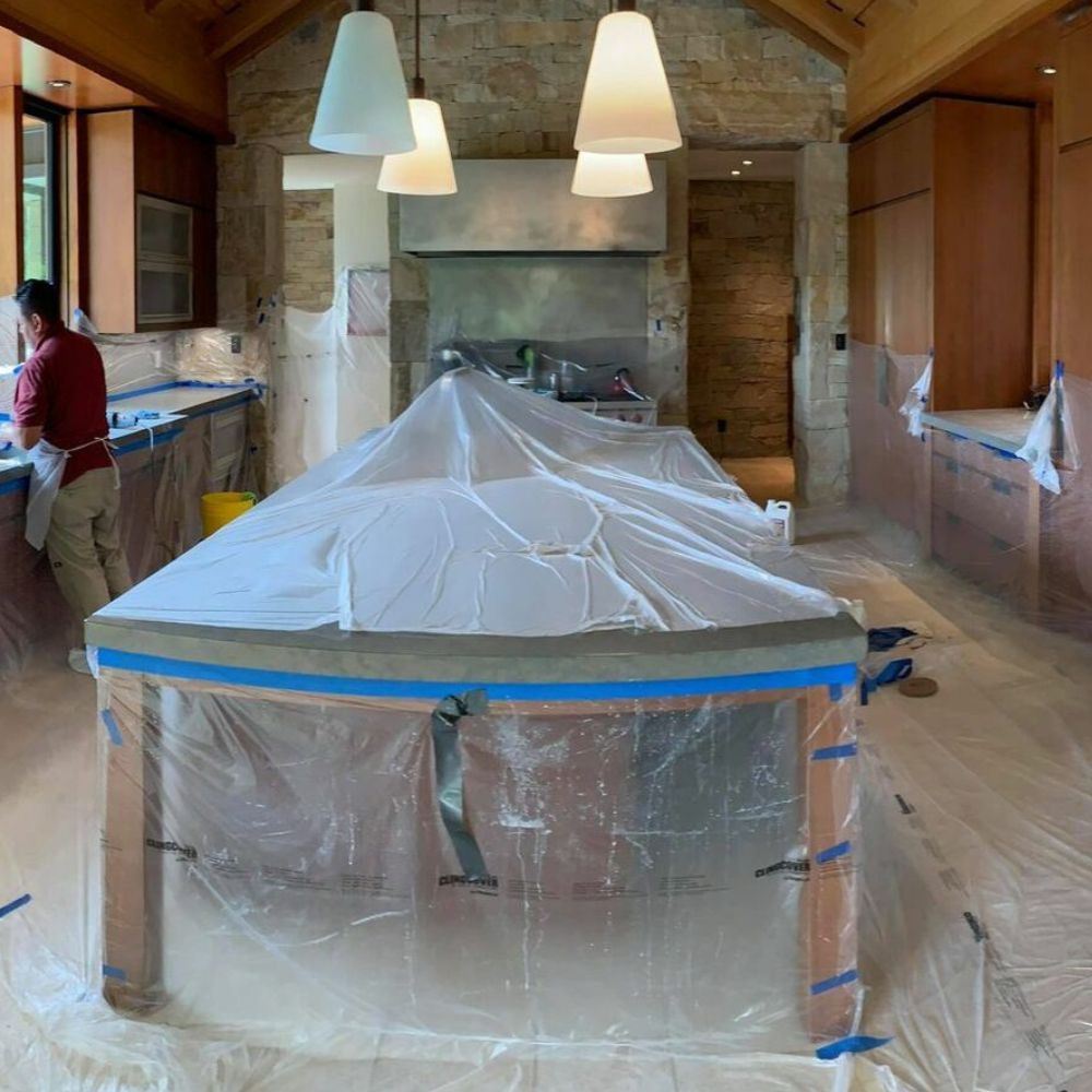 A kitchen with a long table covered in plastic.