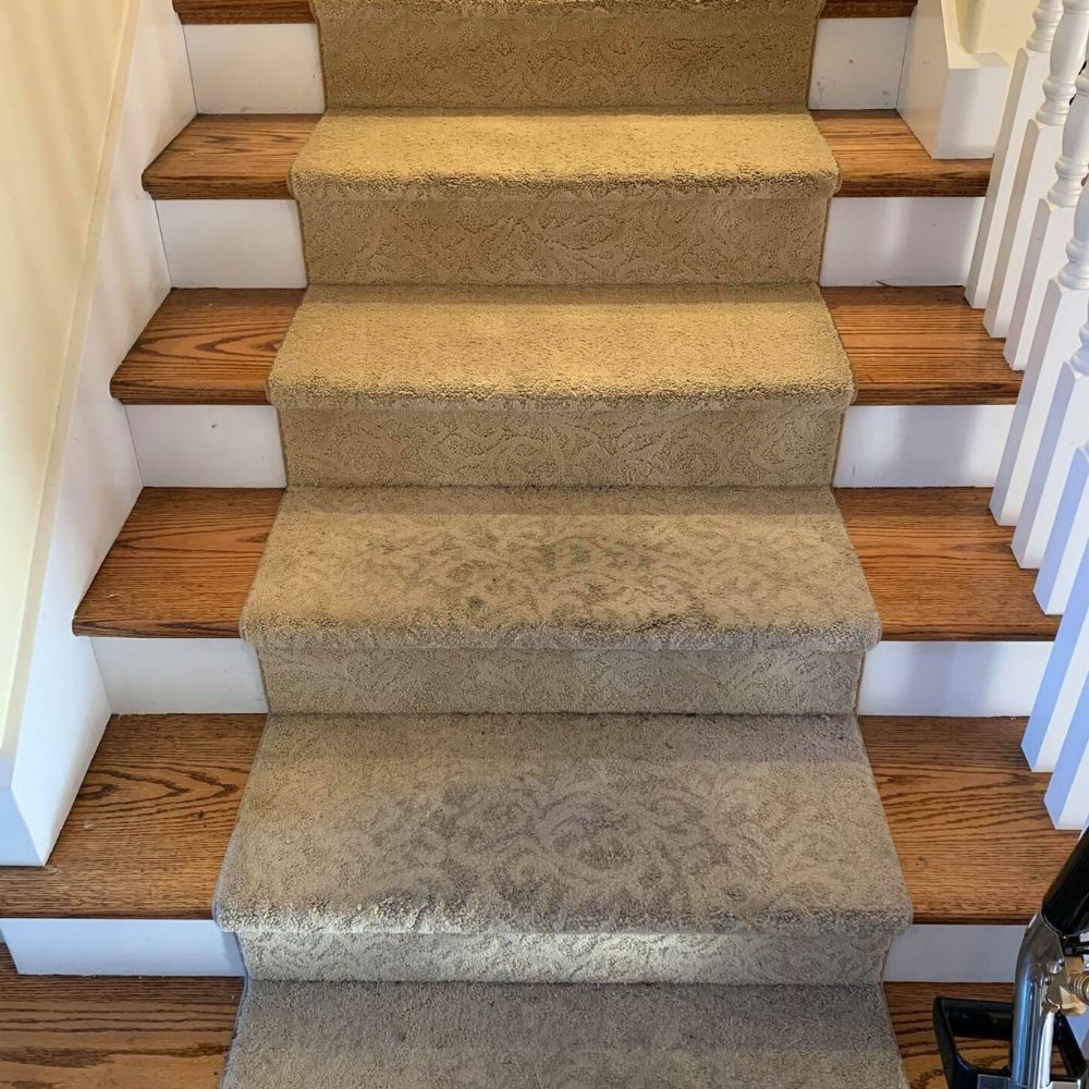 A set of stairs with carpeted steps and wooden steps