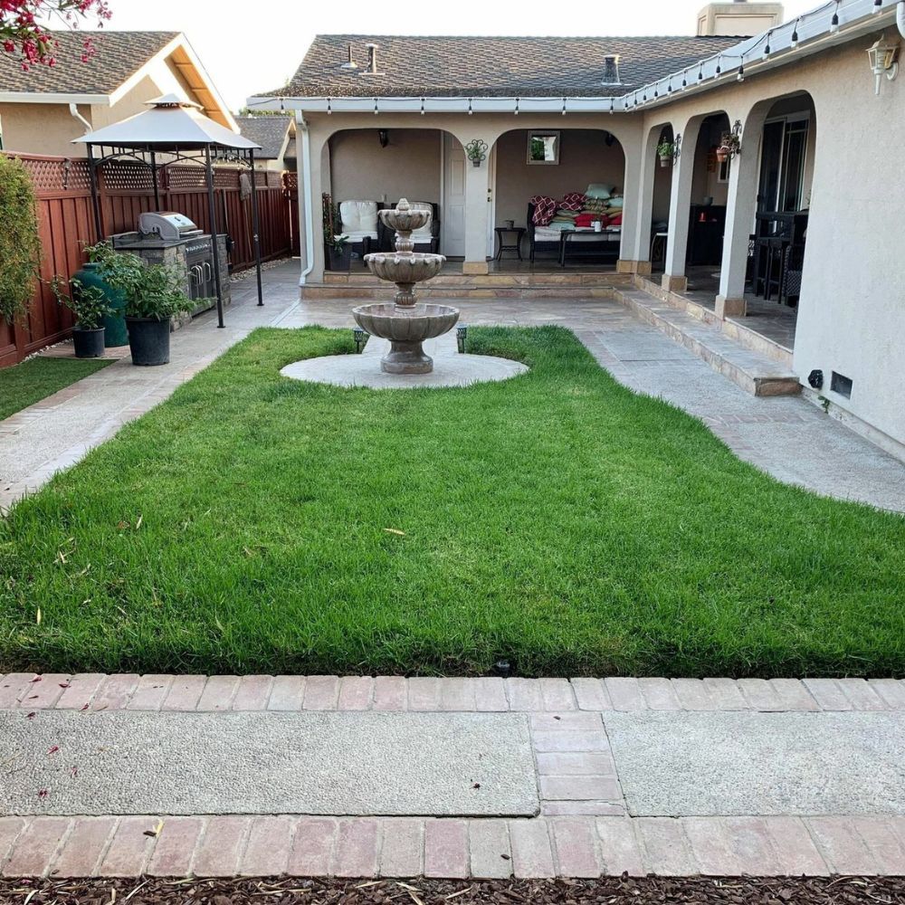 A backyard with a fountain in the middle of it