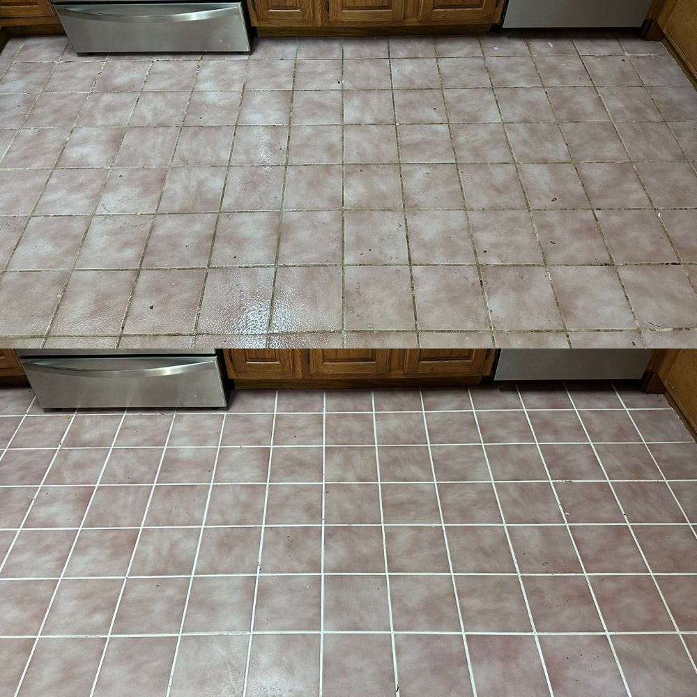 A kitchen floor with pink tiles and a stainless steel dishwasher