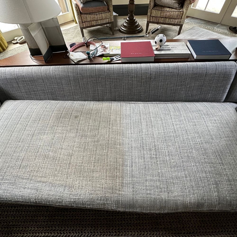 A couch is sitting on top of a table in a living room.
