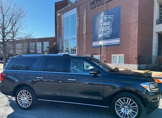 A black suv is parked in front of a brick building