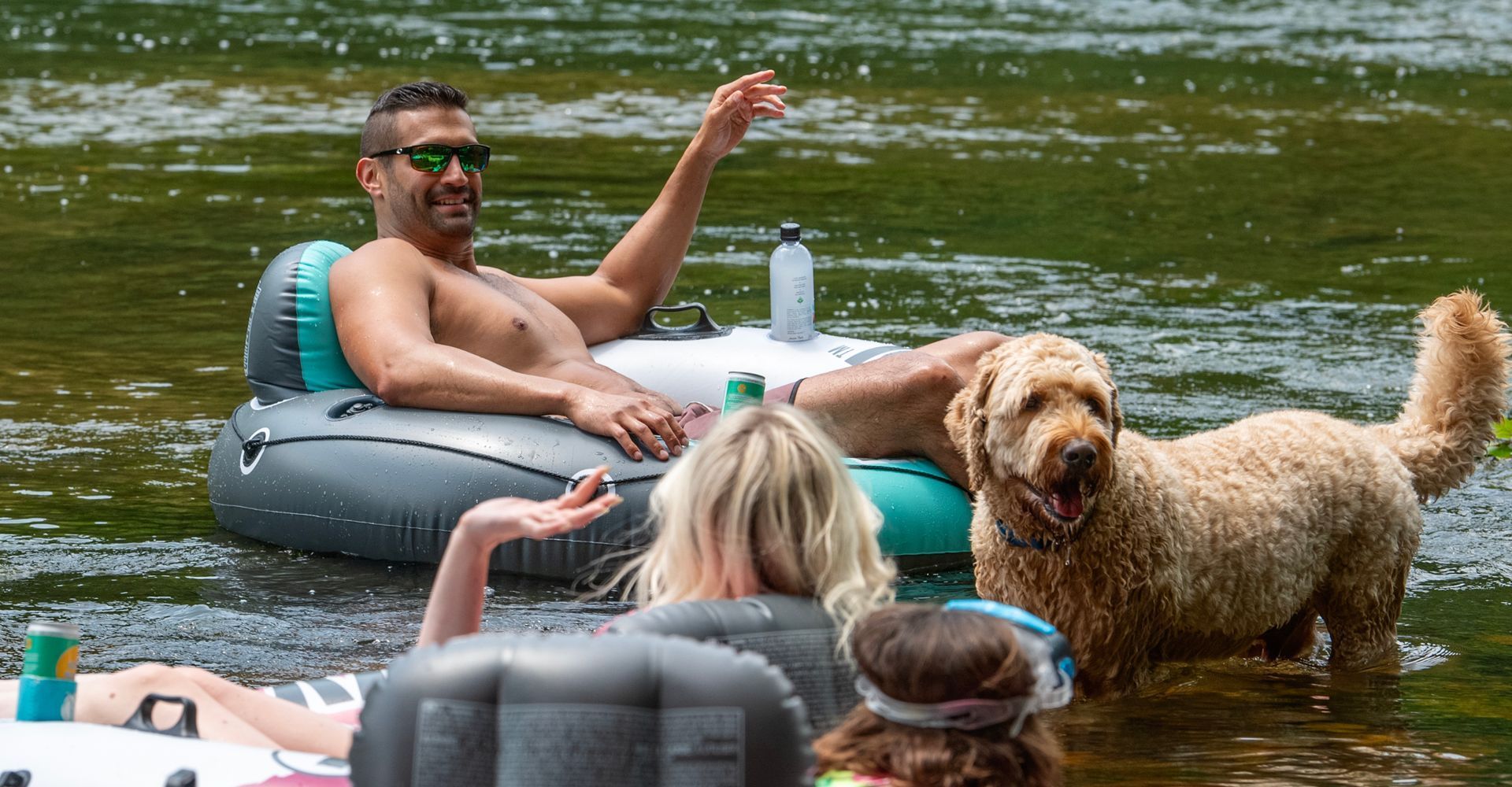 Dog in the river with people tubing