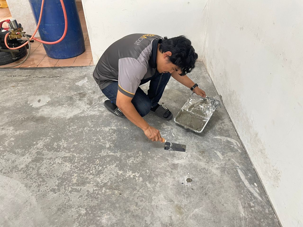 technician patching up holes with cement for anti termite control