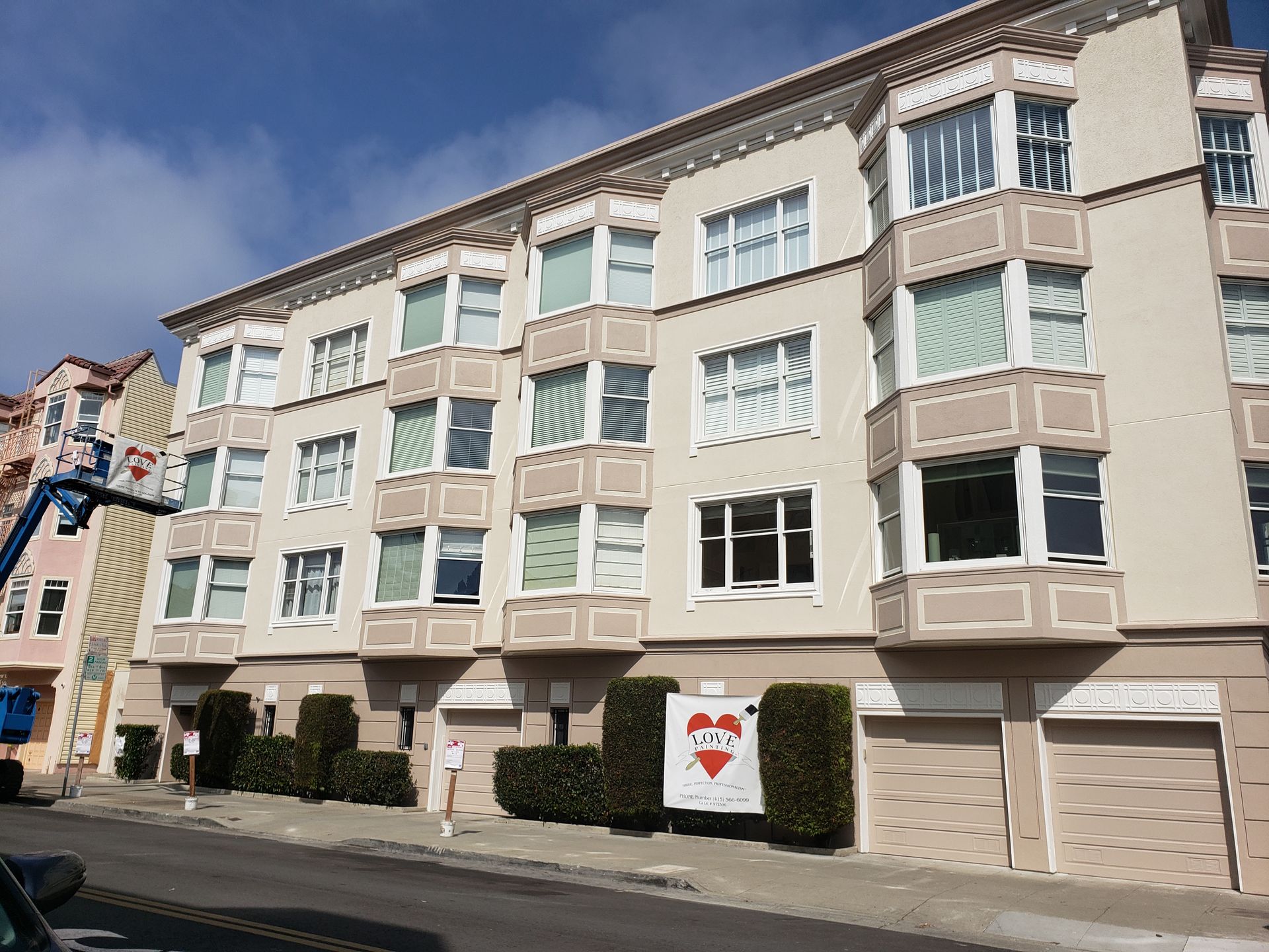 Beige apartment building with bay windows; blue sky.