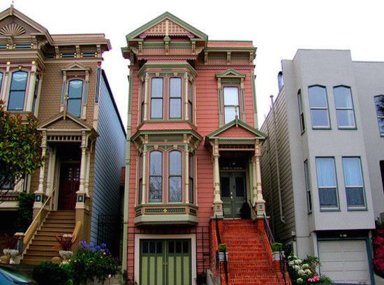 Colorful Victorian houses in San Francisco, with detailed trim and steps leading to front doors.