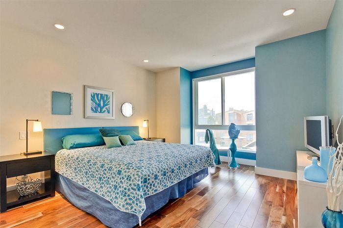 Bedroom with a blue and white color scheme; bed, furniture, window.