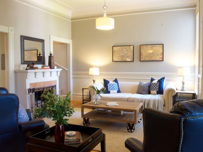 Living room with beige couch, wooden coffee table, fireplace, blue accents, and artwork.