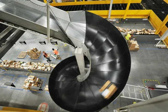 Amazon Spiral conveyor belt transports boxes down to a warehouse floor.