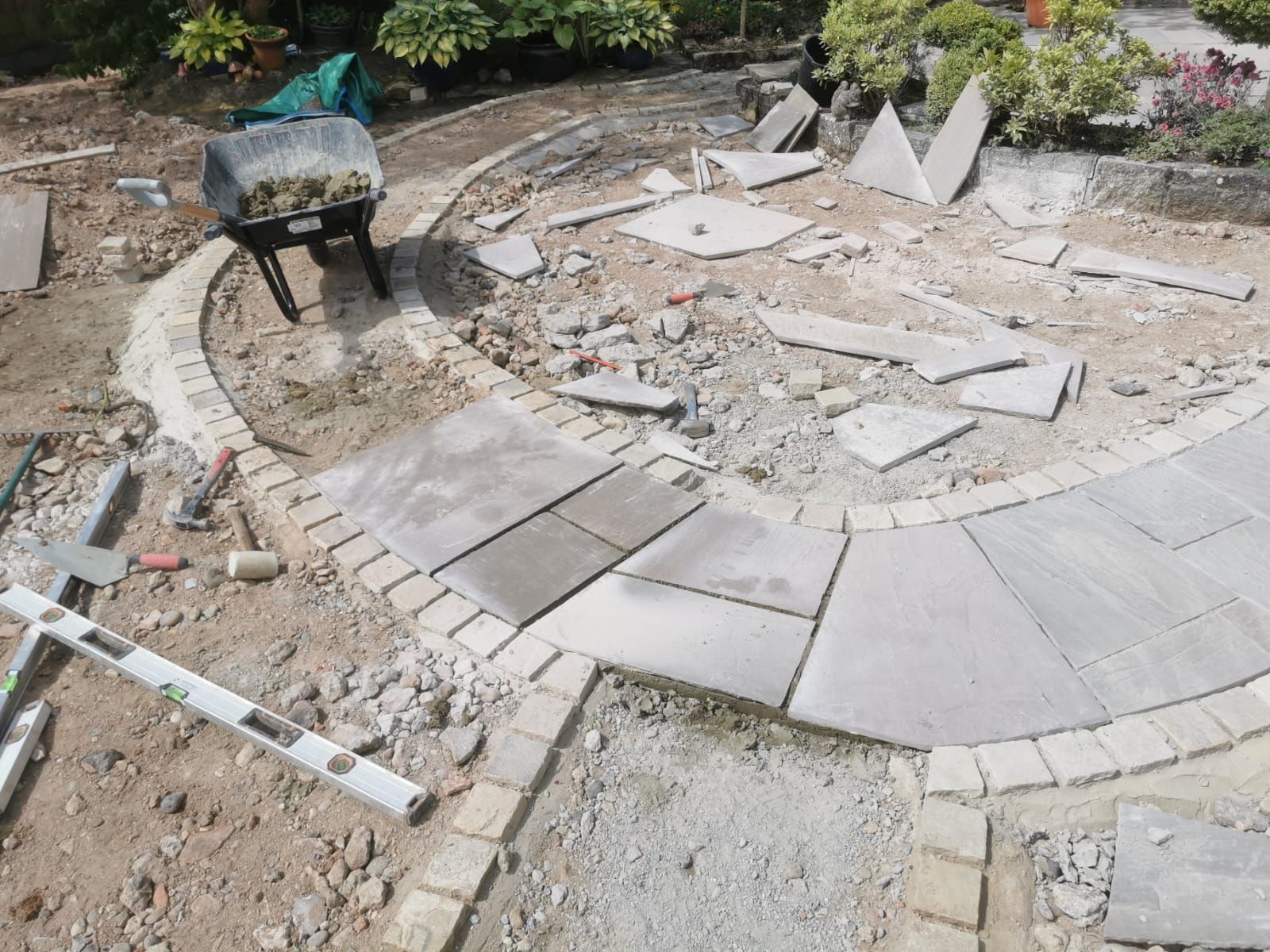 A wheelbarrow is sitting on top of a pile of concrete at Zion Hill Outdoor Spaces