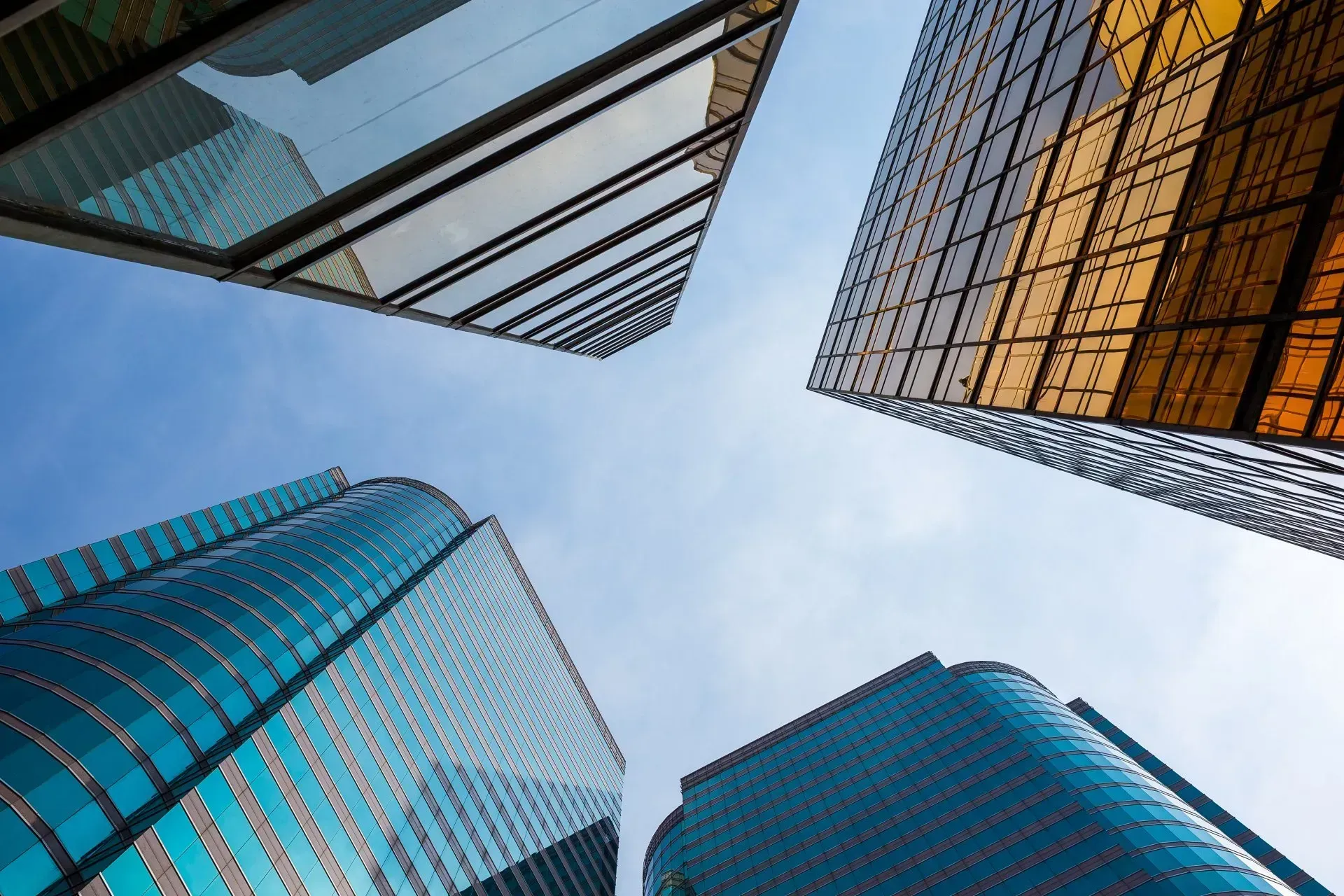 Looking up at a group of tall buildings against a blue sky.