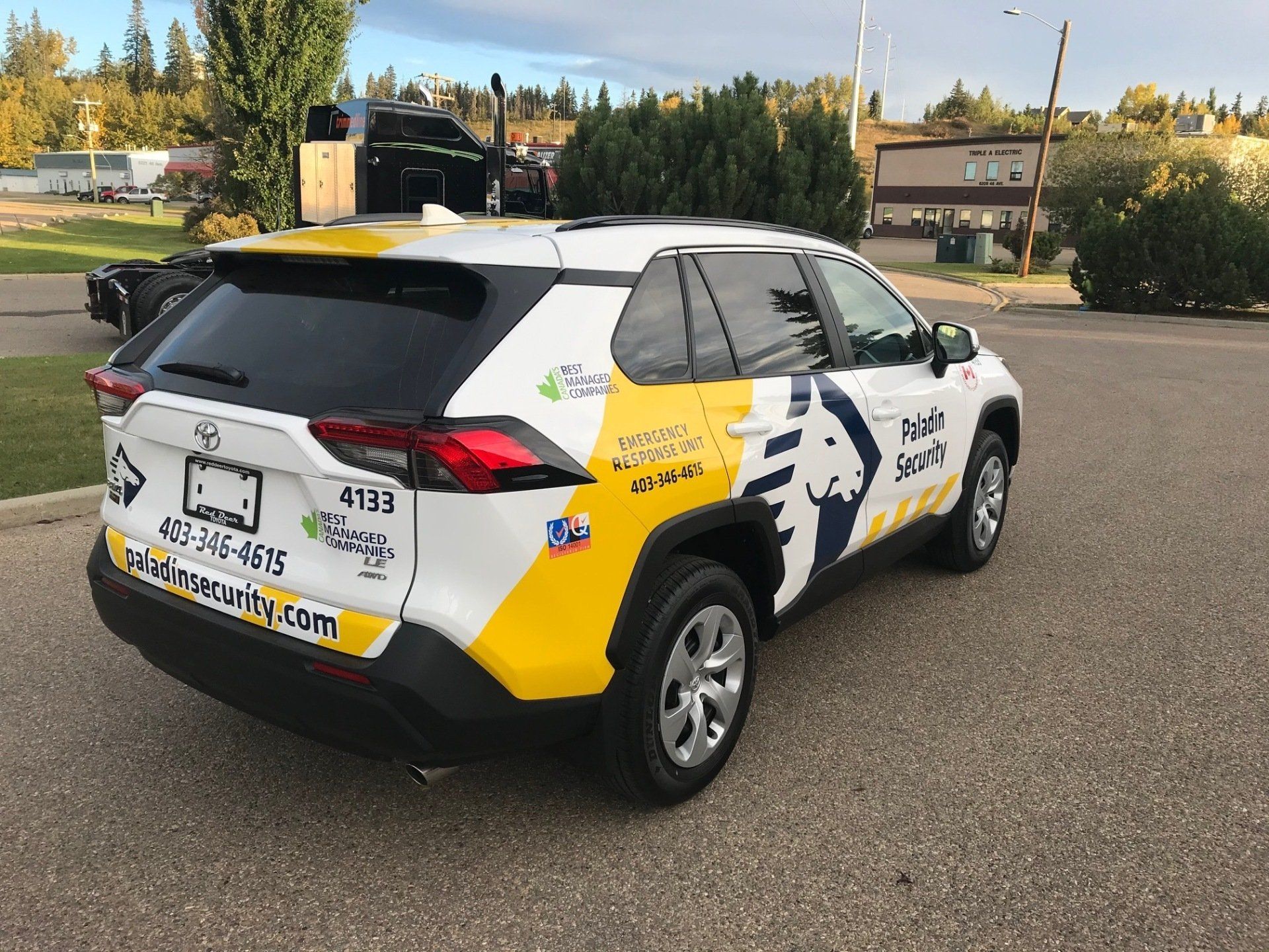 a white and yellow suv is parked on the side of the road