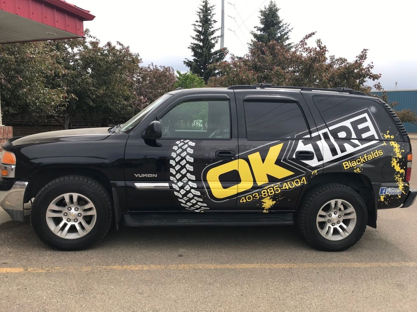 large black suv with with yellow decals and company logo printed on it