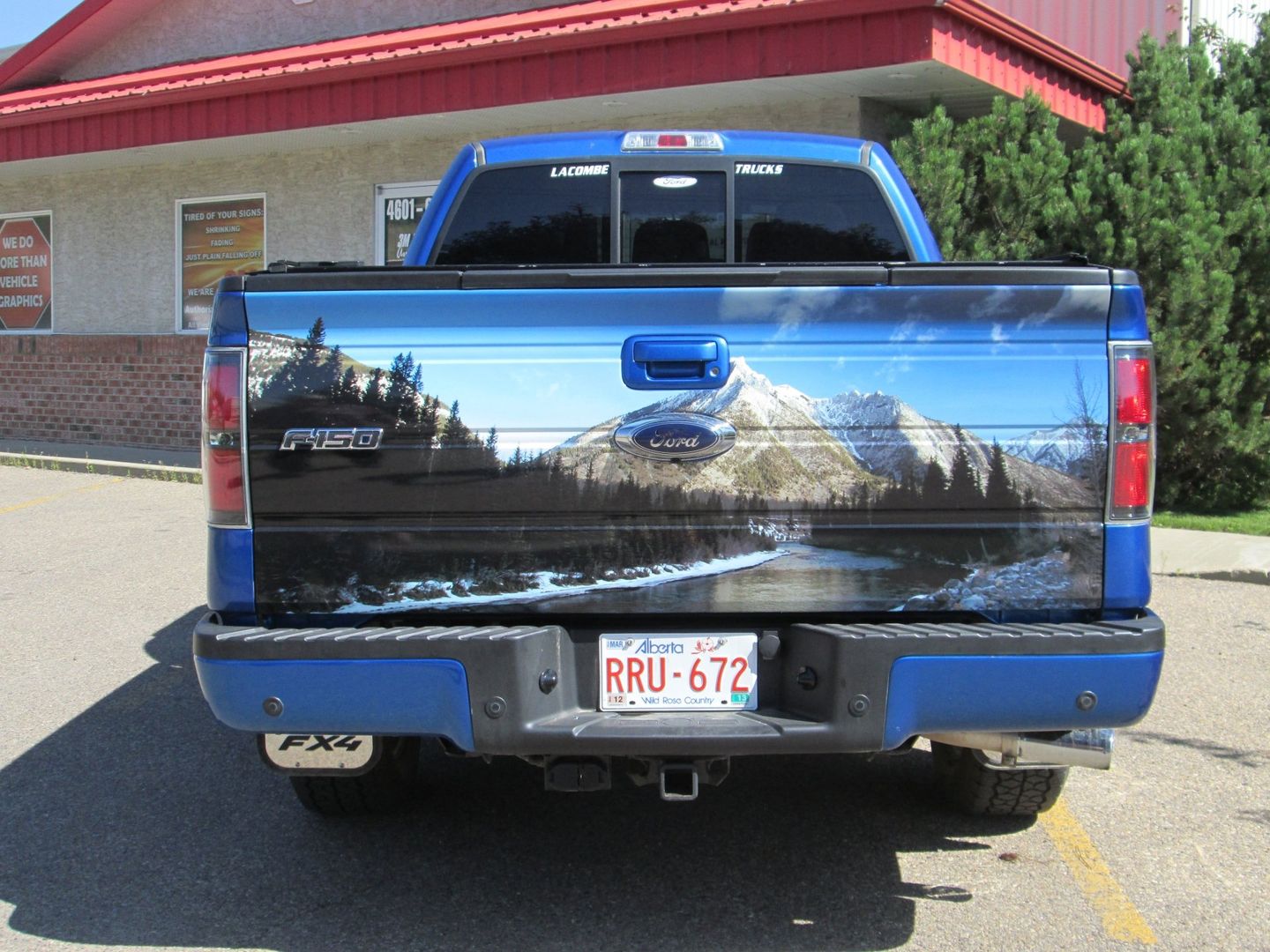 back of blue ford truck with mountain sticker on tailgate