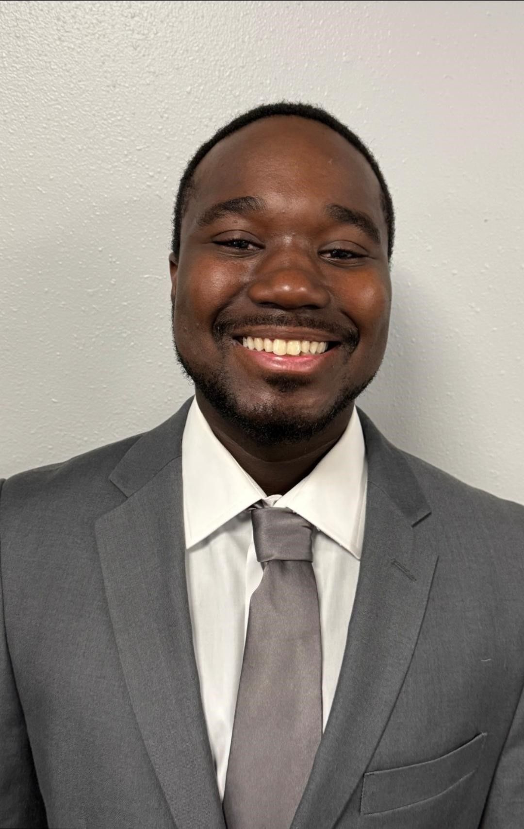 A woman wearing glasses and a white shirt is smiling for the camera.