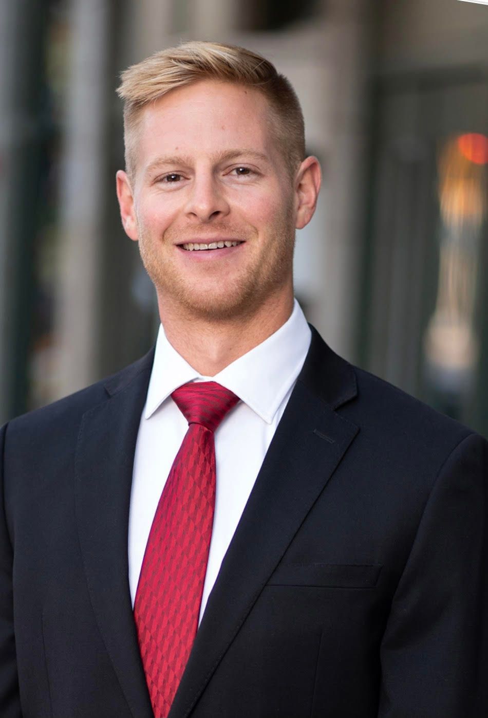 A woman wearing glasses and a white shirt is smiling for the camera.