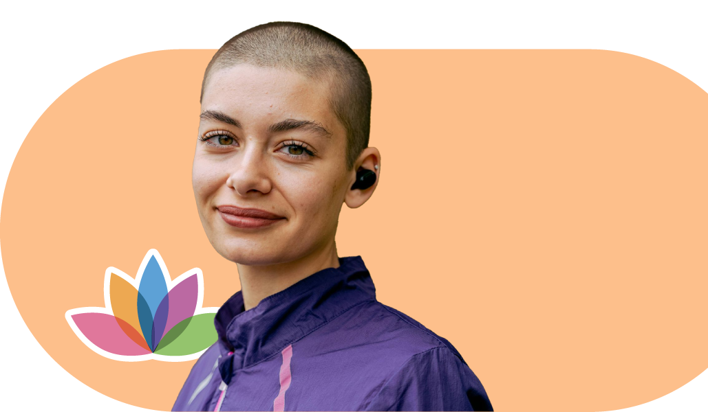 A woman with a shaved head is wearing headphones and a purple shirt.