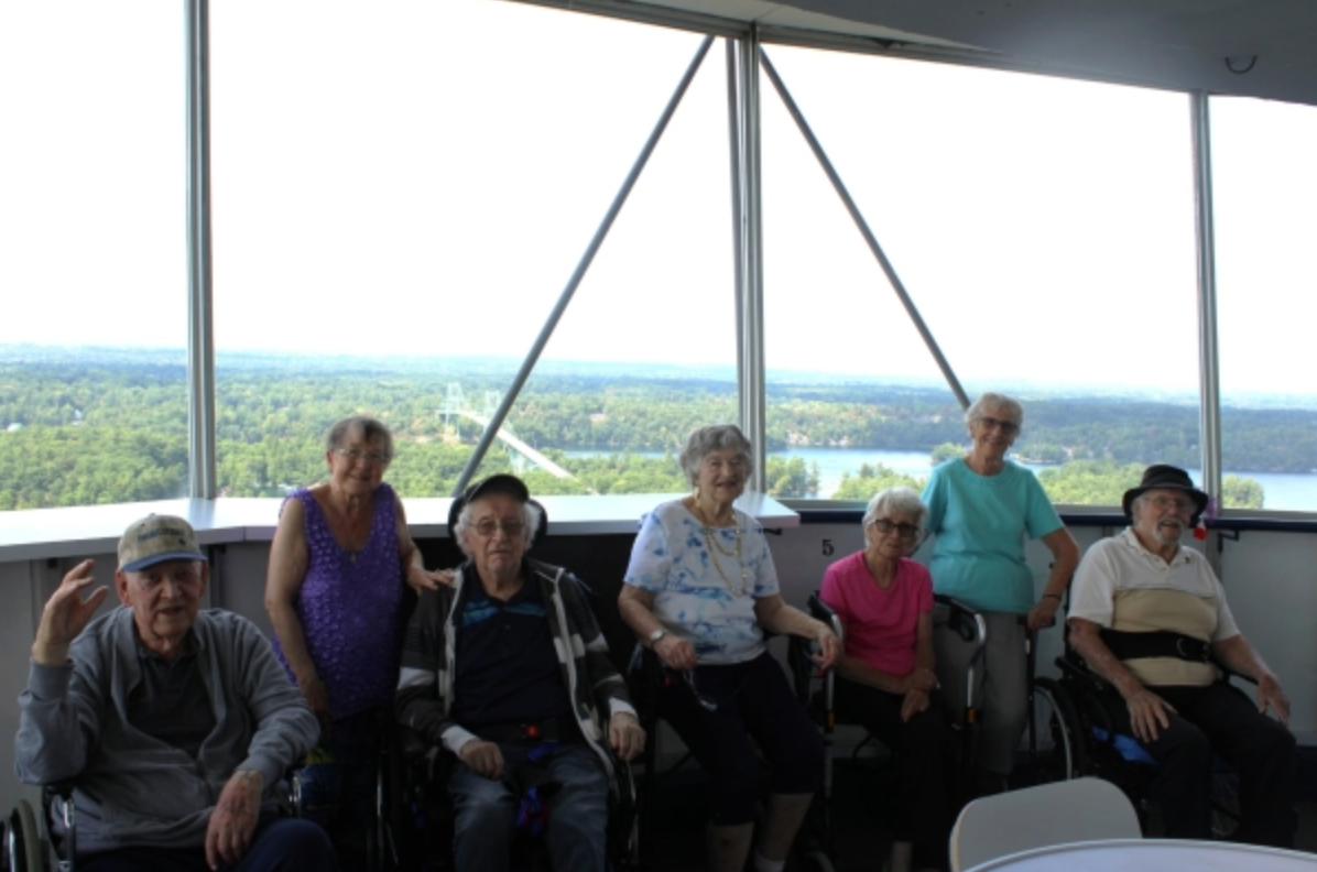 Group seated indoors by large windows with a scenic landscape in the background
