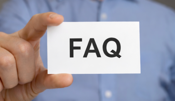 Hand holding a white card labeled “FAQ” in black text