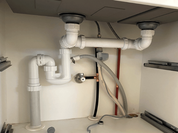plumbing pipes and fixtures under the sink