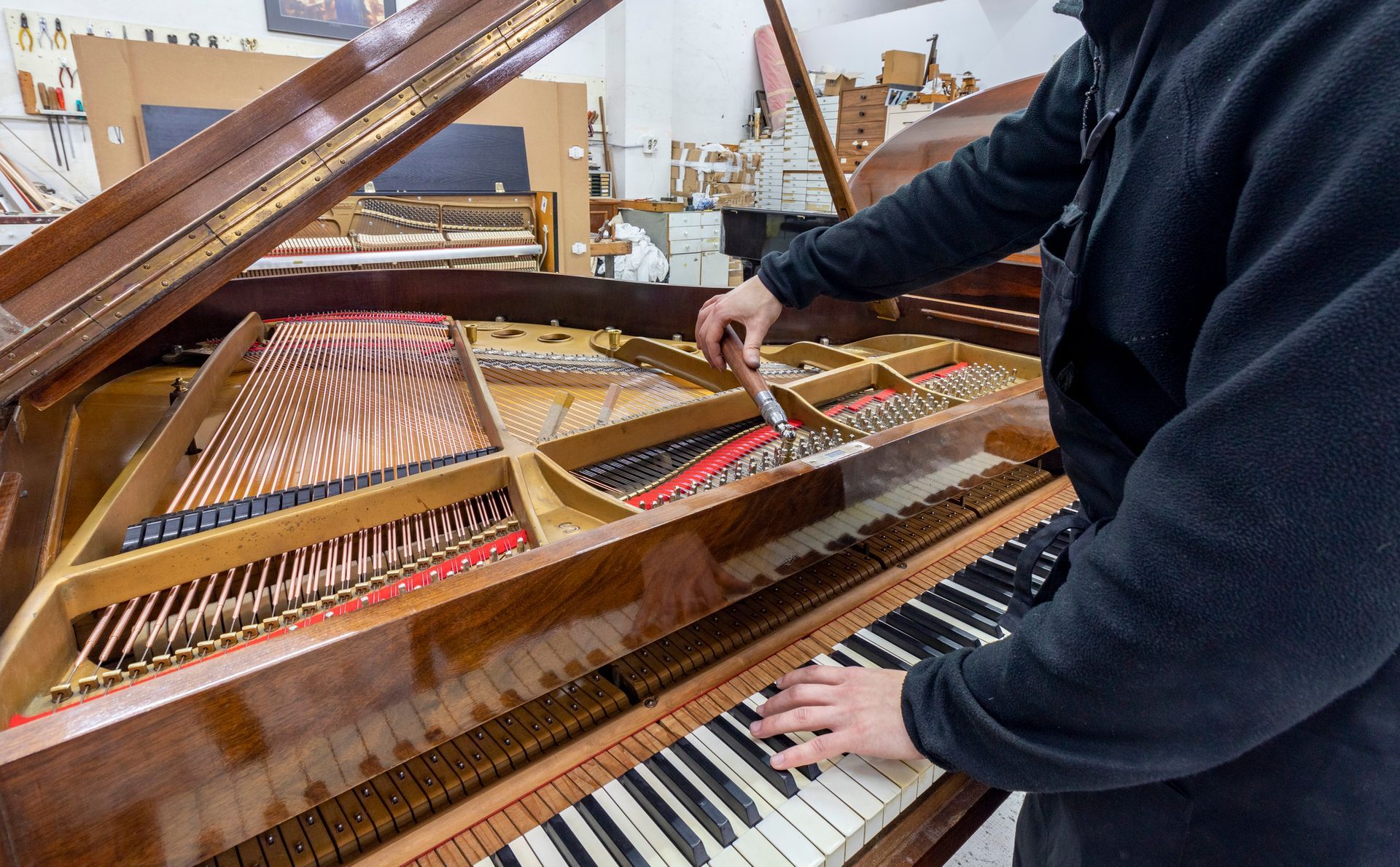 A man is tuning a piano.