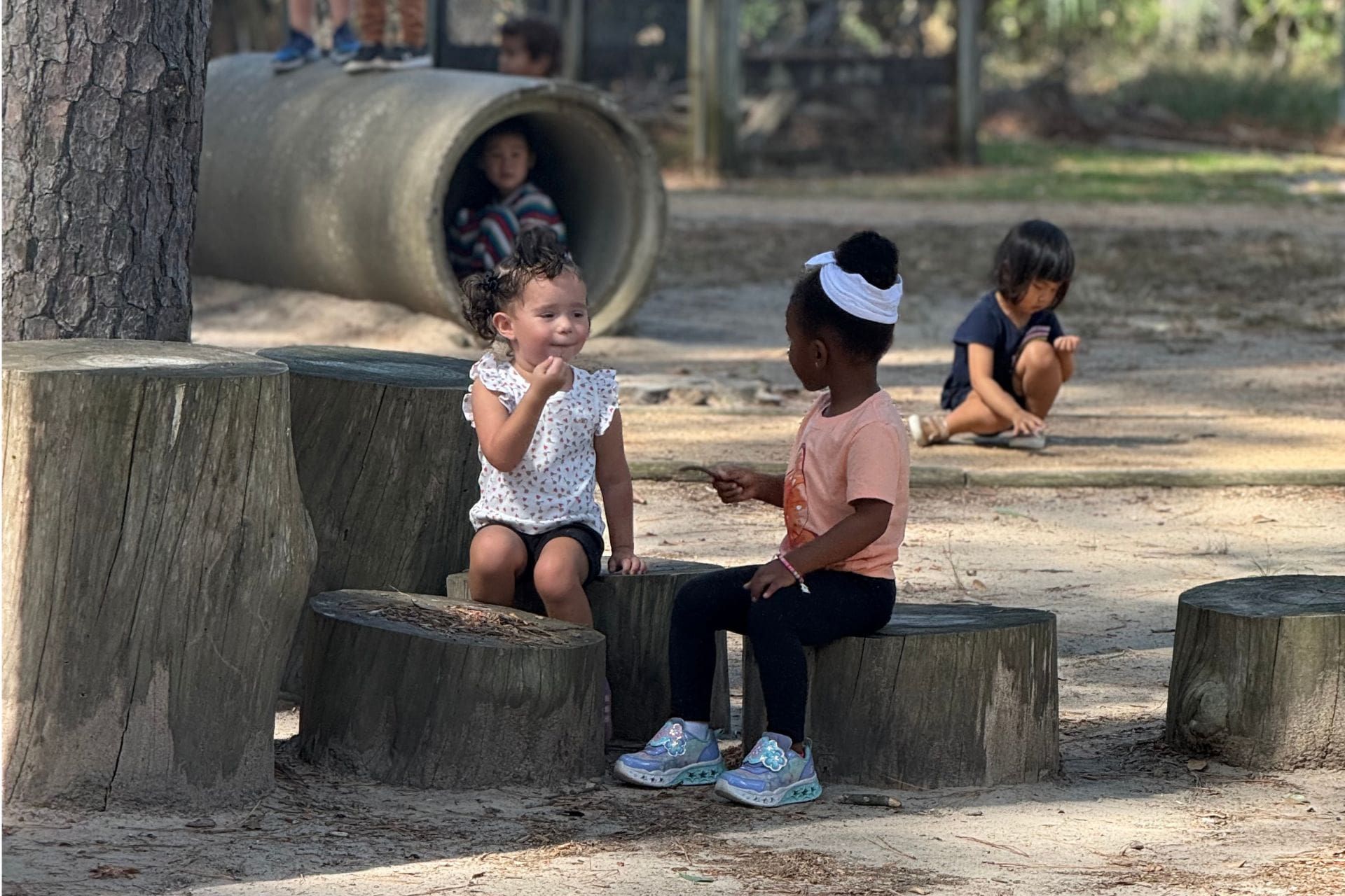 Montessori child hammering wood with focus, showing persistence and independence in work.