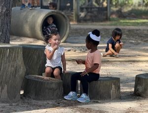 Montessori children playing together outside, learning empathy, cooperation, and friendship skills.