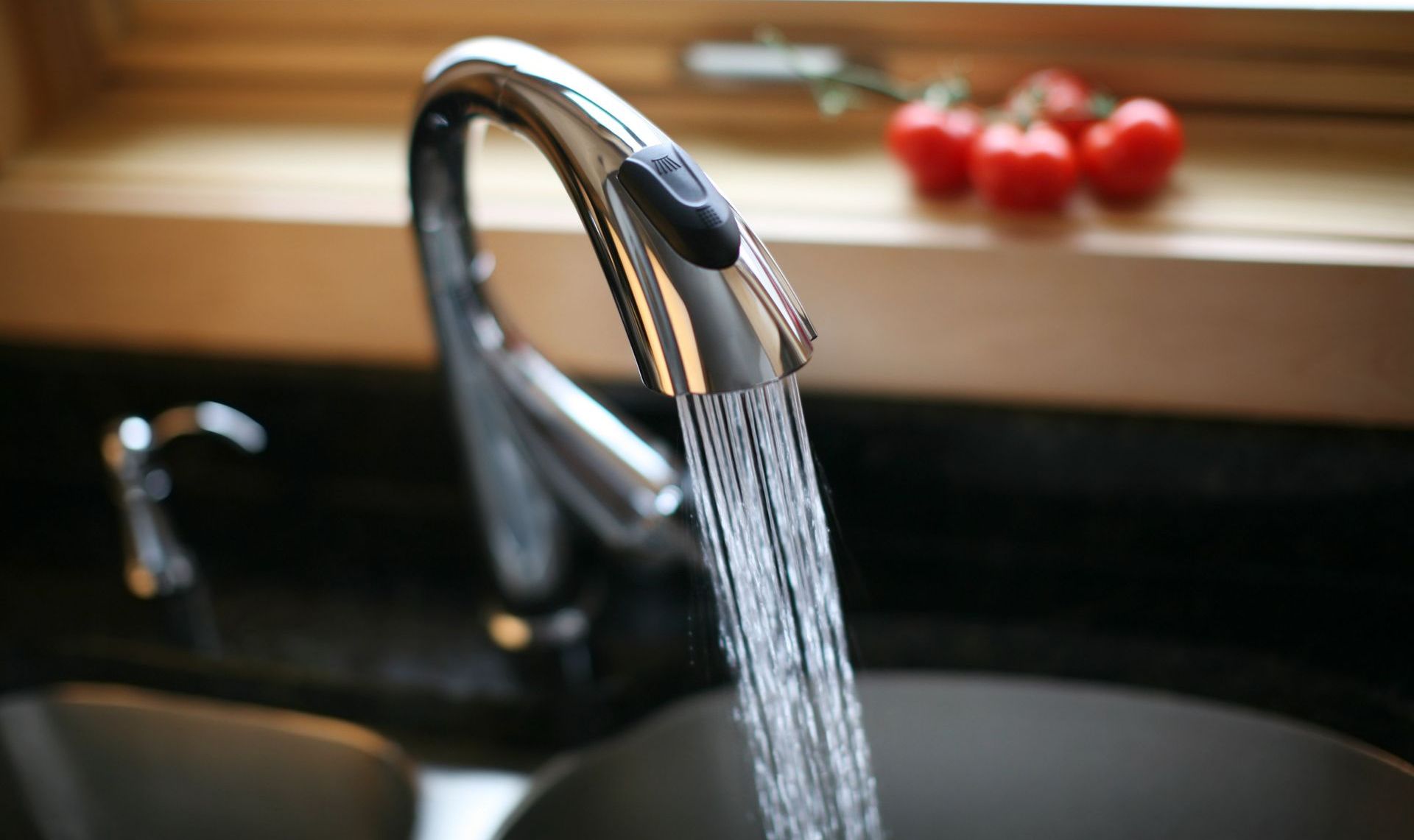 A person is fixing a faucet with a wrench.