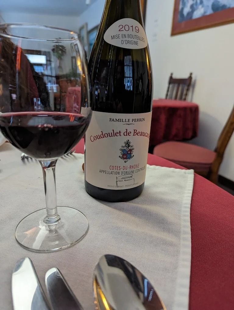 Salad bowl with tuna, sliced hard-boiled eggs, olives, tomatoes, red onion, and fresh basil on a gray surface