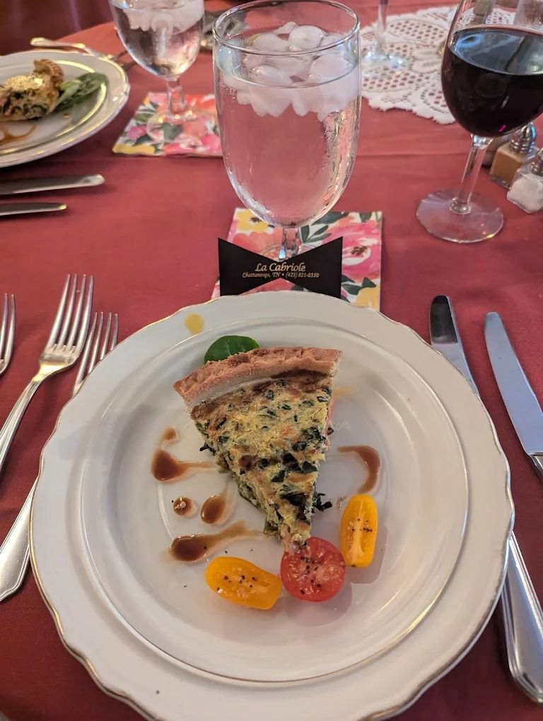 Chef pouring sauce from spoon onto a salad, wearing white uniform