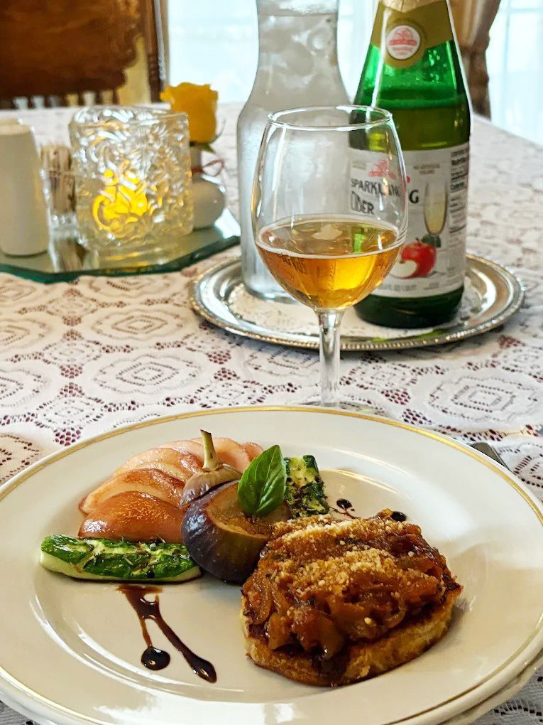 Pan-seared salmon on yellow sauce, with vegetables, on a white plate.