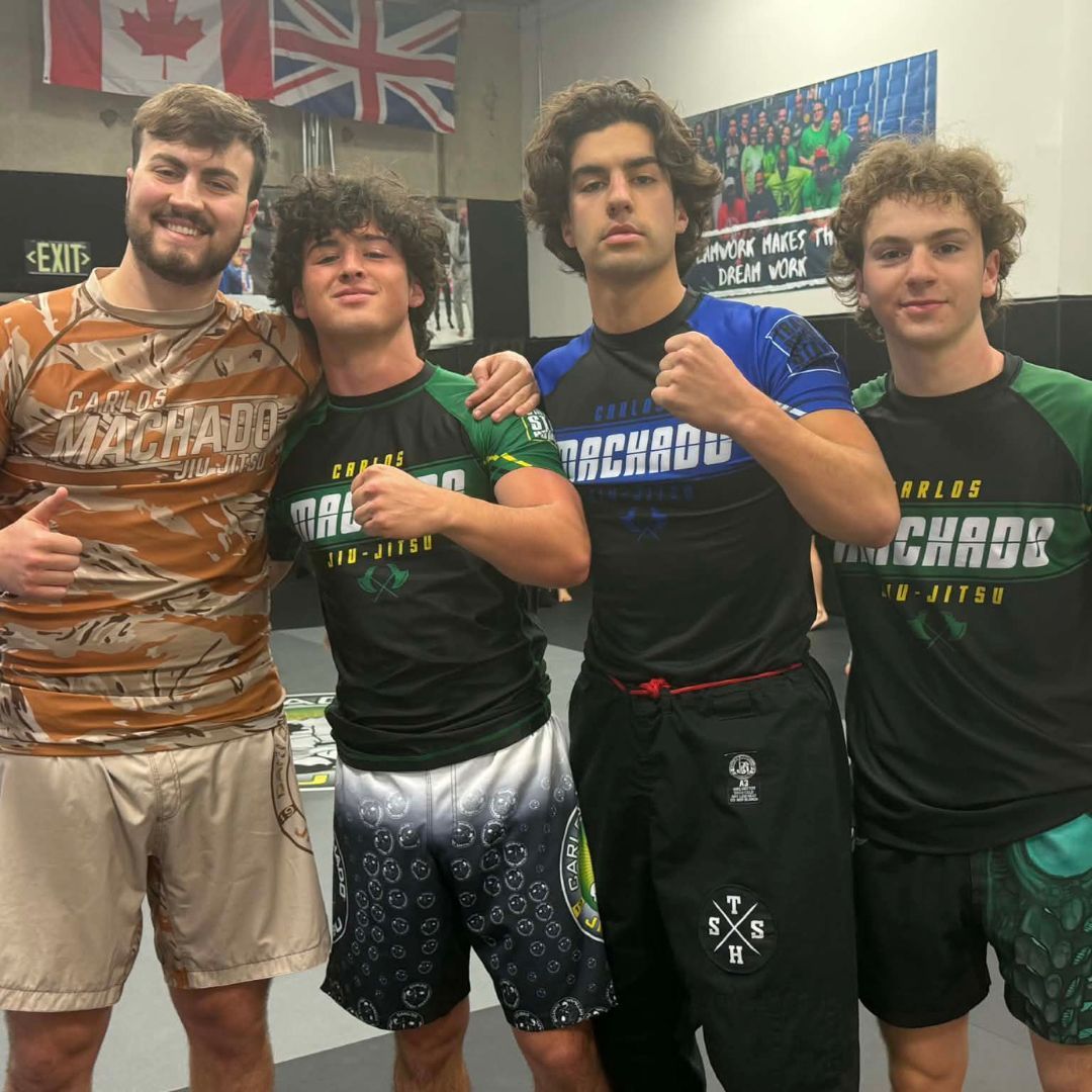 Four men in athletic gear, posing for a photo in a gym.