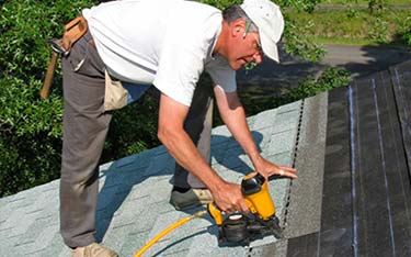 Man fixing roof - Roofing services in Flemington, NJ