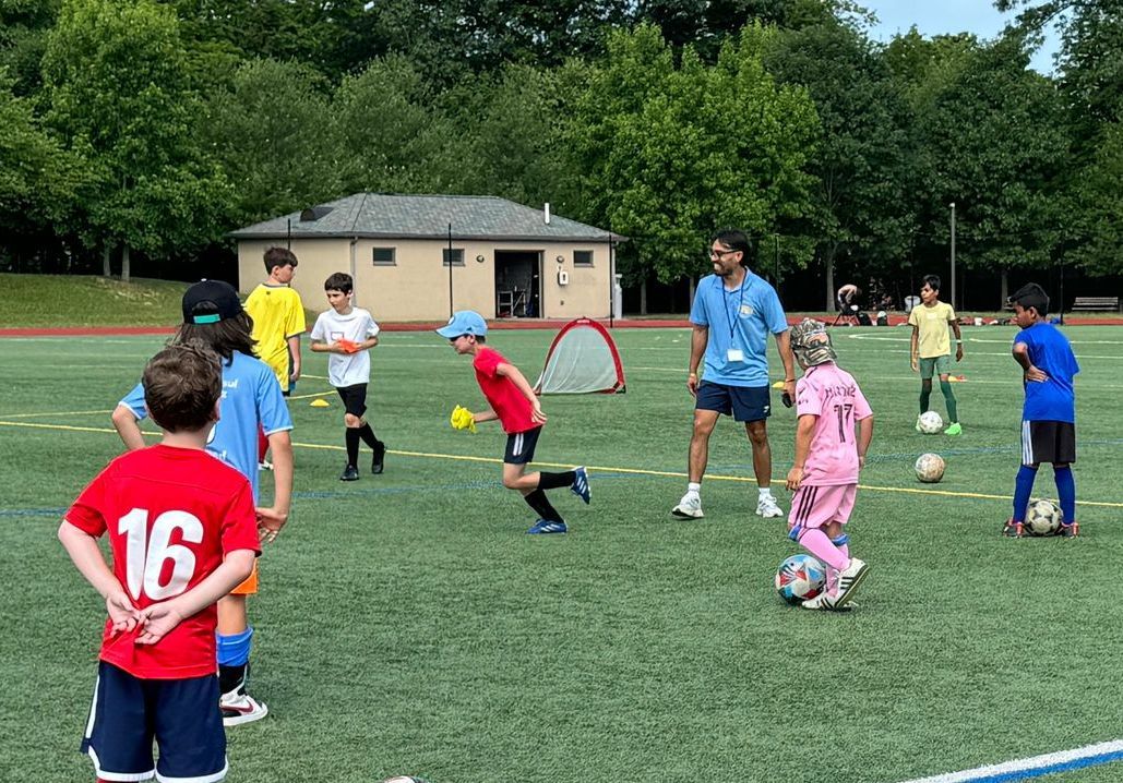 A group of children are playing soccer on a field.