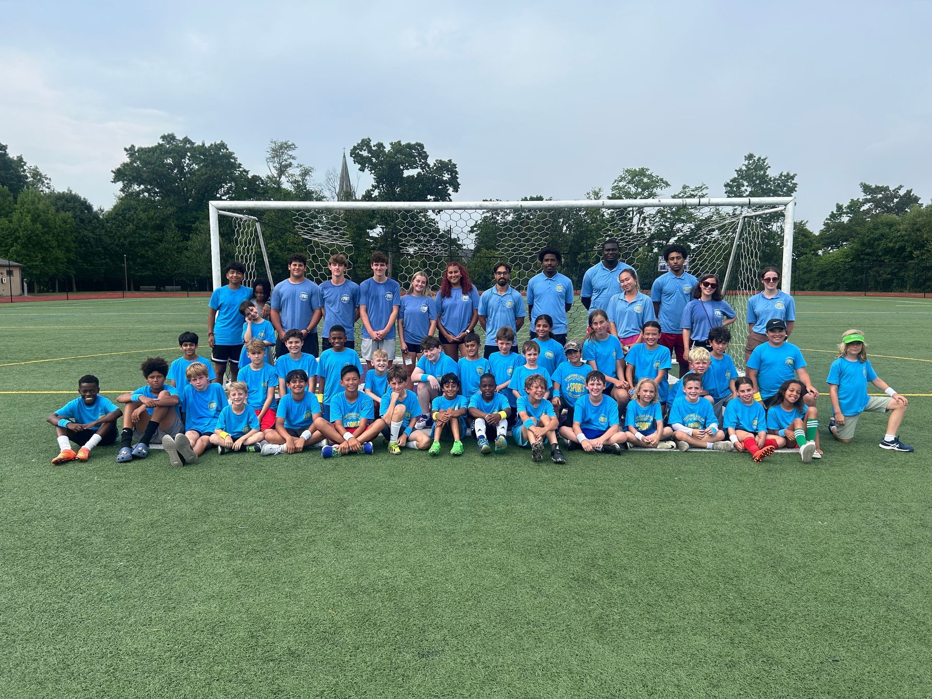 A group of children are posing for a picture on a soccer field.