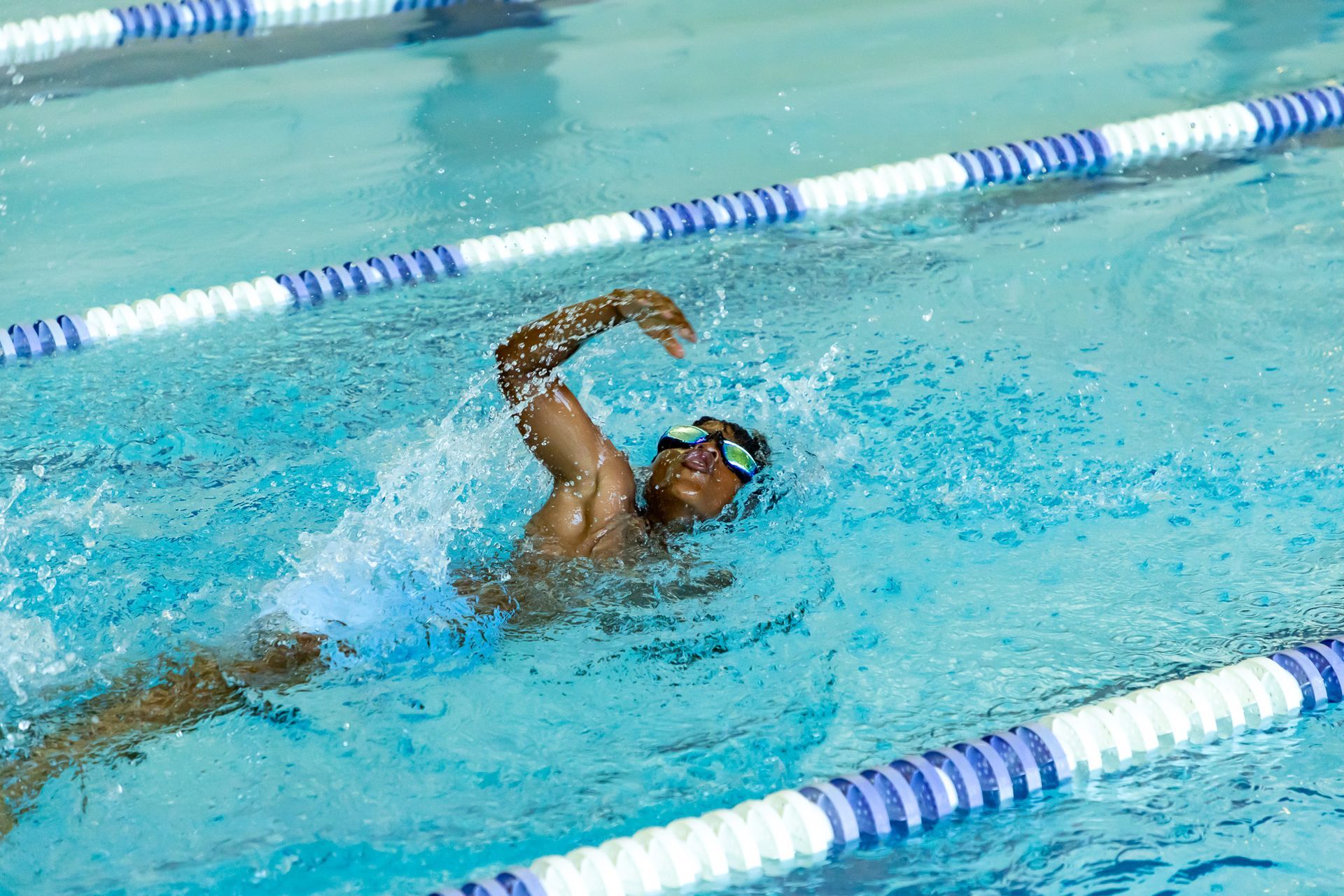 A young man in a yellow shirt and blue shorts is throwing a frisbee.