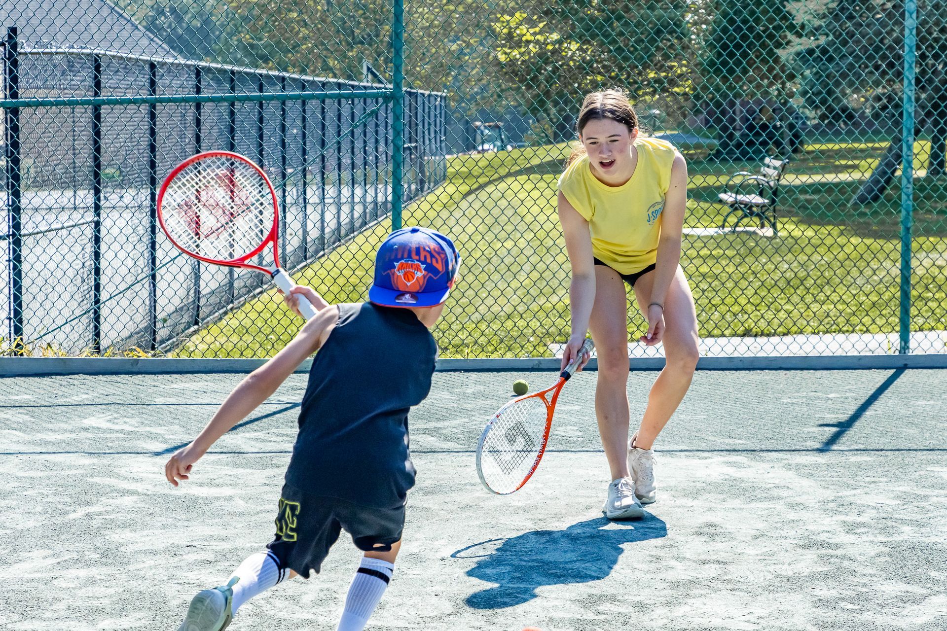 A young girl is playing tennis on a court