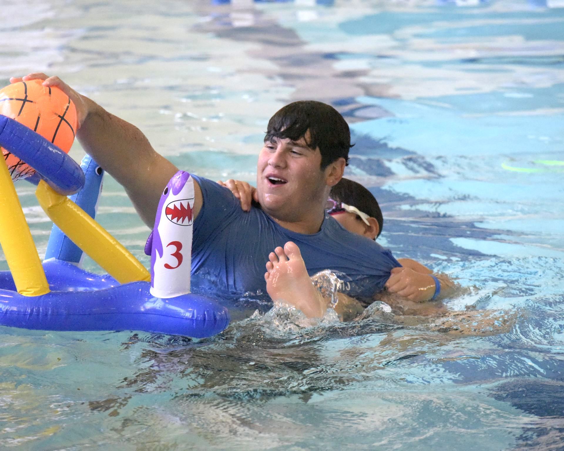 A group of people are playing a game in a swimming pool.