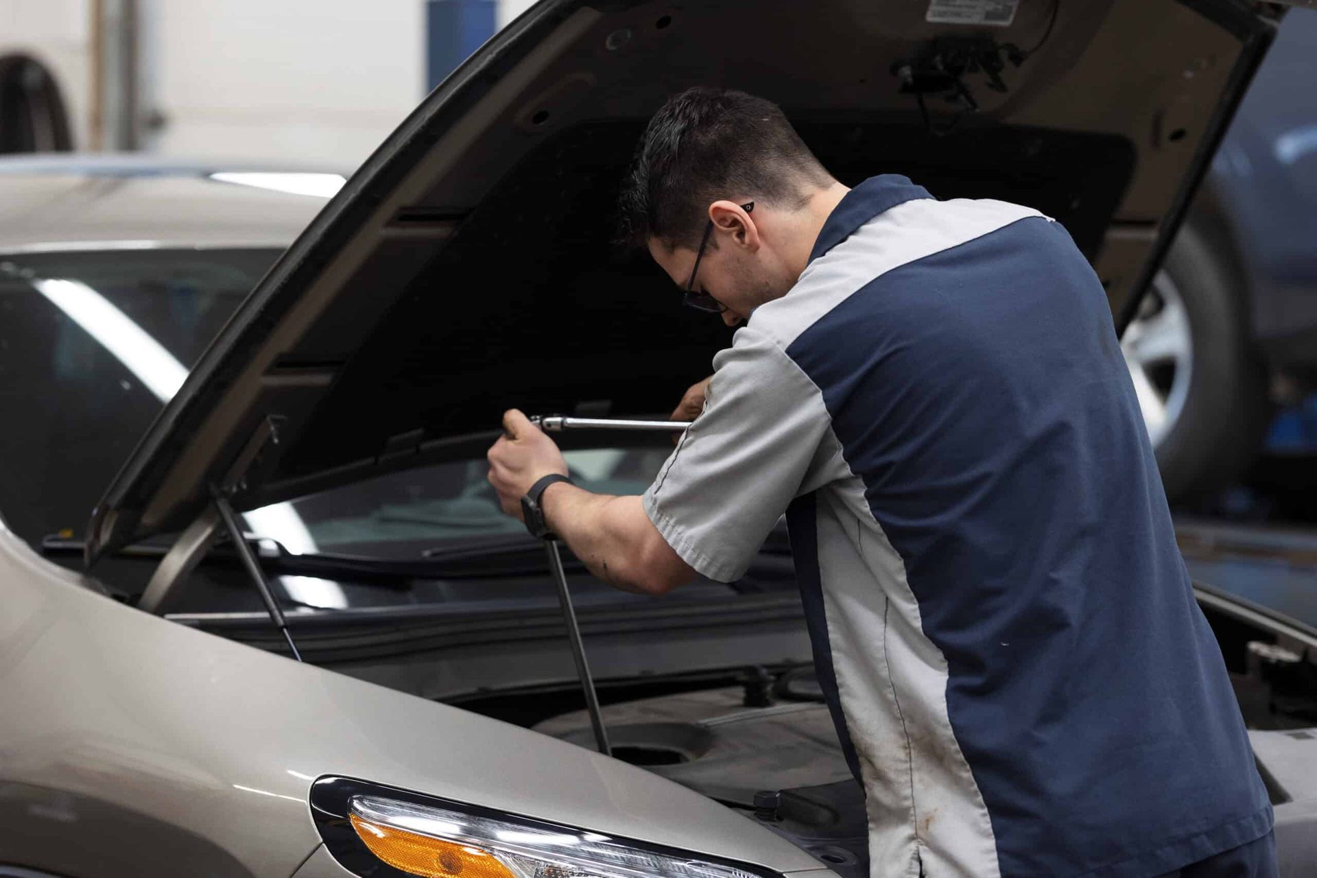 Mechanic working on a car engine with the hood open. | Joe's Slinger Service