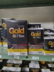 NAPA Gold oil filter boxes on a shelf. The boxes are black, gold, and white. | Joe's Slinger Service